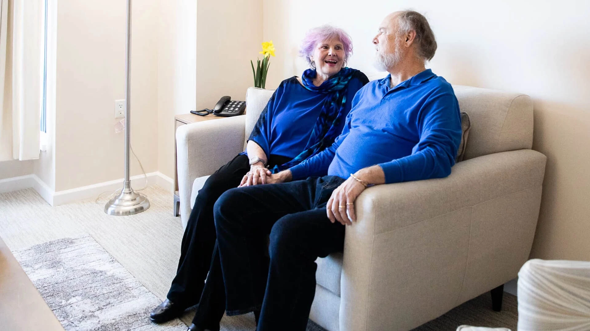 A couple sitting on a couch in a living room.