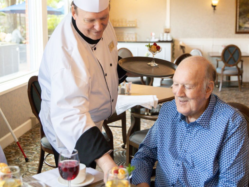 chef serving resident a meal