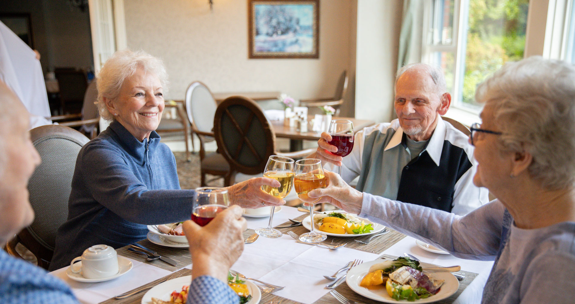 residents enjoying meal with wine